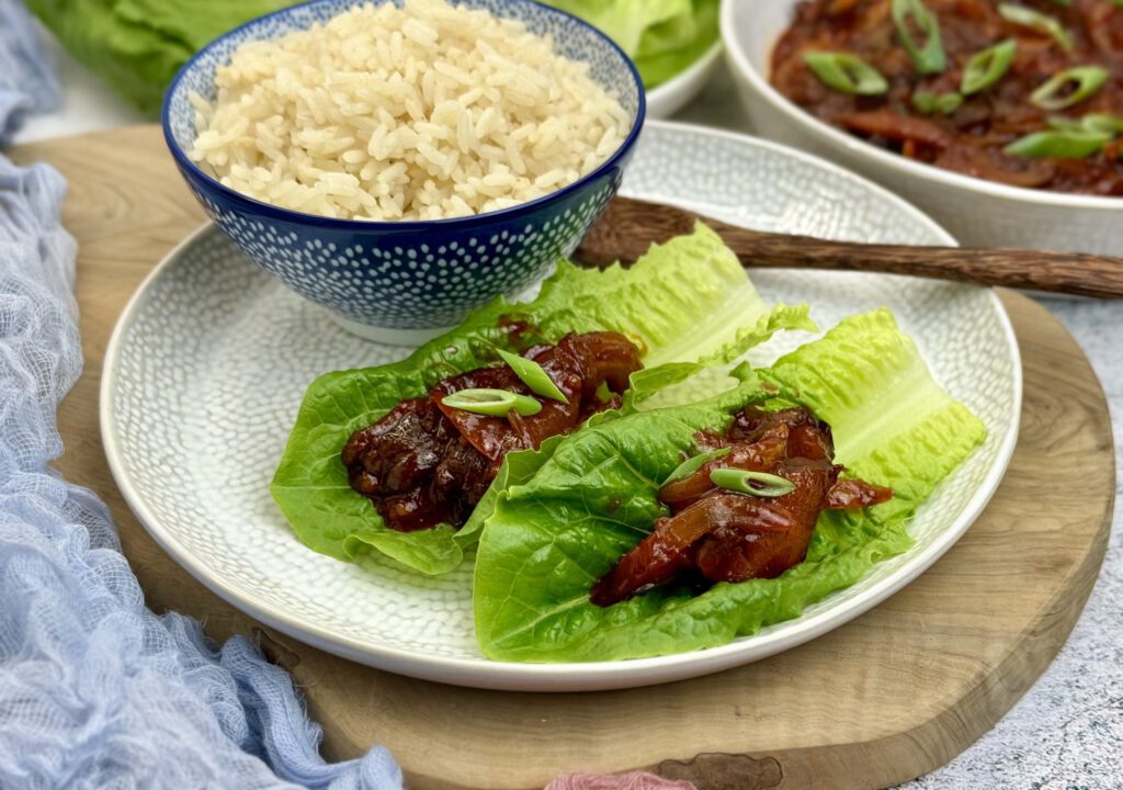 Vegan Jeyuk Bokkeum, an easy midweek meal serve the spicy mushrooms with rice and lettuce.