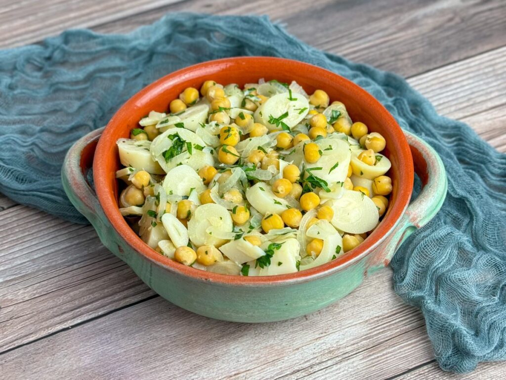 Vegan Bacalhau com Grão - Hearts of Palm and Chickpea Salad served in a terracotta  bowl, garnished with fresh parsley